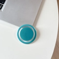 Close-up of magnetic mint green phone grip on a laptop showing minimalist round design - Deep Lake Blue