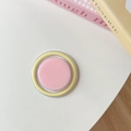 Dettaglio di un fard in crema rosa tondo in custodia acrilica con bordo decorativo giallo - Rosa e Giallo