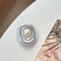 Detailed view of silver oval metal phone grip featuring a large central white pearl - Magnetic Pearl Swirl Style / Matte Silver