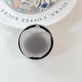 Detail view of a matte grey apple-shaped telescopic phone grip on a white surface - (Dopamine) Magnetic-Sandwich Apple-Black