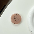 Detail of round light pink resin phone socket with black minimalist speckled pattern - Coffee