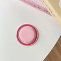 Primo piano di fard in crema rosa tenue in astuccio tondo rosa vivace su tavolo bianco - Rosa & Rosa Rosso