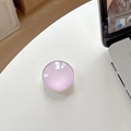 Close-up of purple iridescent round crystal phone grip holder on a white desk - Pink Purple