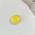 Close-up of a glossy yellow crystal glass round phone stand with smooth reflective surface - Yellow