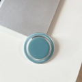 Minimalist cyan blue magnetic ring phone holder on a clean desk next to a laptop - Blue