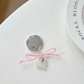 Detalle de lazo rosa y colgante de corazón de perlas en soporte de móvil plateado - Estilo de Lazo de Corazón Rosa Plateado