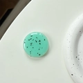 Macro view of mint green round phone socket with black speckles and glossy finish - Milky Green