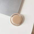 Detail of the minimalist magnetic circular foundation cream jar on a modern sleek surface - Milk Tea