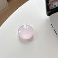 Top view of a pink translucent crystal glass phone grip showing high-gloss texture on white desk - Light Pink
