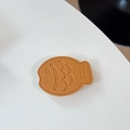 Macro shot of caramel leather taiyaki phone socket with detailed stitching and texture - Leather Taiyaki / Golden Brown