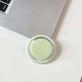 Close-up of minimalist mint green magnetic phone socket grip on a white desk setup - Light Grass Green