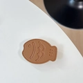 Detail of a brown leather fish-shaped phone grip with fine stitching and embossed details - Leather Taiyaki / Brown