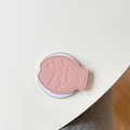 Dettaglio macro del supporto per telefono in pelle rosa a forma di pesce con cuciture - Rosa