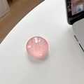 Close-up of pink crystal glass phone grip with marble texture on a white desk surface - Textured Deep Pink