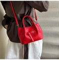 Detalle del bolso de cubo rojo tejido con hebilla de metal y correa ajustable - Rojo