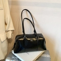 Minimalist black glossy leather bowling bag with silver logo and dual shoulder straps - Black