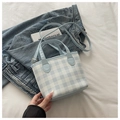 Détail du sac en toile vichy bleu clair montrant la bandoulière réglable et la boucle - Bleu