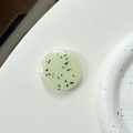Minimalist light green phone grip with black speckles and a glossy resin finish - Light Grass Green