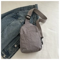 Macro detail of grey waterproof nylon chest bag with metallic M logo and woven strap - Gray