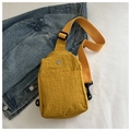 Detail of yellow nylon chest bag showing water-resistant texture and metal M logo - Yellow