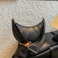 Bolso de hombro media luna negro con diseño acolchado vertical y hebillas metálicas doradas - Negro