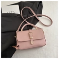 Detail of pink faux leather handbag featuring a golden buckle and stylish textured design - Pink