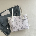Fashionable tote bag featuring butterfly and star prints with white handles and side drawstrings - Silver