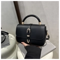 Detail der schwarzen Lederhandtasche mit rundem Griff und Goldschnalle auf Sockel - Schwarz