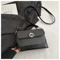 Detail of contrast stitching, woven gray texture, and horseshoe lock on the handbag - Black