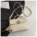 Detail of woven texture and metal horseshoe lock on cream crossbody handbag - White