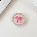 Close-up of pink bow knot phone socket with sparkling rhinestones and woven texture - Pink