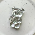 Close-up of a transparent 3D bear crystal phone grip on a white ceramic plate - Bear / Water Wave