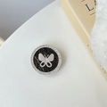 Macro shot of silver butterfly phone socket with black marble pattern and crystals - Black