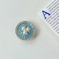 Nahaufnahme der Perlenblüte mit Strass auf einem hellblauen faltbaren Handy-Halter - Transparenter Klebestil (Perlenblume) / Blau