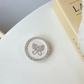 Macro detail of silver butterfly phone socket with rhinestones and leather base - White