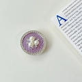 Nahaufnahme einer runden Handyhalterung mit lila Stoff, Perlen und Strasssteinen - Transparenter Klebestil (Perlenblume) / Lila