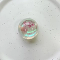 Macro shot of iridescent laser bear crystal ball phone socket on a white ceramic plate - Crystal Ball / Holographic Multicolor