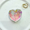 Macro shot of a multifaceted heart-shaped phone grip with iridescent laser finish and white base - Magnetic Geometric Large Heart - Colorful Laser
