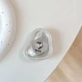 Detail of silver heart phone socket with crystal inlay and engraved logo on white stand - Foil Texture Style 11