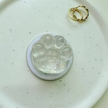 Macro view of iridescent cat paw phone socket with heart detail on a white plate - Magnetic Cat Paw - Aurora