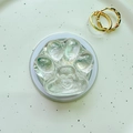 Close-up of clear resin cat paw phone grip with heart detail on a decorative tray - Magnetic Cat Paw - Tin Foil Texture