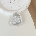 Detailed view of an elegant 3D silver butterfly phone grip on a fluid pebble base - Tinfoil Texture #18