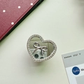 Macro detail of heart-shaped phone grip with silver bow, mirror surface and rhinestones - Small Heart Pendant / Silver