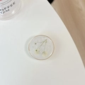 Macro detail of round resin phone socket featuring real white flowers and pearls - Transparent Stand - Gold Ring Pearl Gypsophila