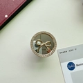 Detailed view of luxury gold phone grip with crystal rhinestones, mirror, and metal bow - Small Round / Gold