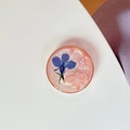 Vista macro del supporto per telefono con fiore blu secco, perla e resina rosa glitter - Supporto Trasparente - Anello D'oro Perla Sestupla Profitto - Nuvola Lampo Rosso