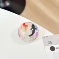 Macro shot of 3D koi fish resin phone grip with colorful iridescent sparkling base - Black Gold Double Fish Style (Blue Light No. 9)