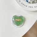 Macro shot of green heart phone grip with silver flakes and gold nicemood metal plate - Green