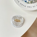 Dettaglio macro del supporto per telefono a cuore con glitter argento ed emblema labbra dorate - Bianco