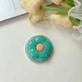 Close-up of a floral phone grip with orange and green petals on a desk setup - Dark Green